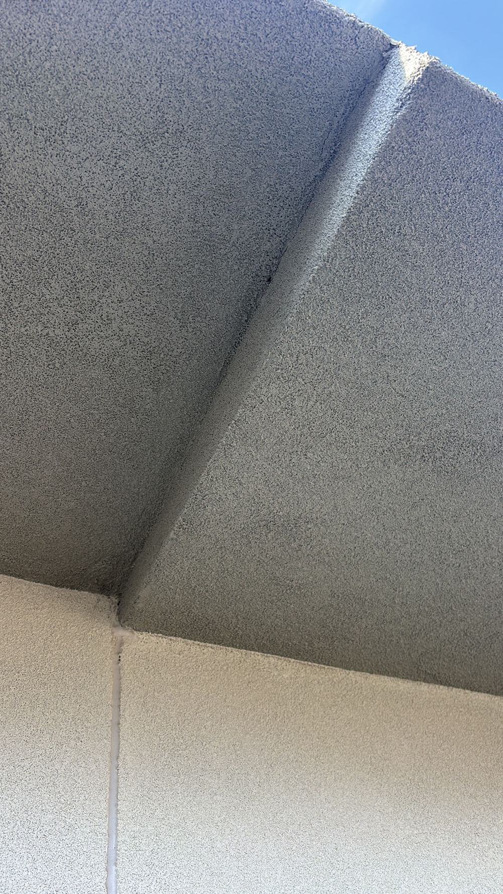 Render bridging a control joint that needs a flexible sealant instead, found during a pre-handover inspection in Mambourin